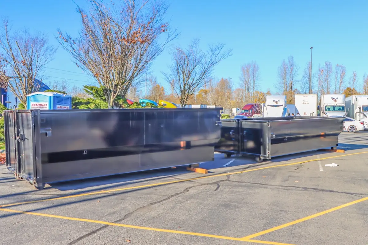 Professional dumpster rental service with roll-off container on residential driveway in Wayne